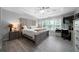 Comfortable main bedroom with a decorative headboard, tray ceiling with fan, and wood-look flooring at 1630 Marsanne Nw Ter # 27, Kennesaw, GA 30152