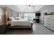 Spacious main bedroom featuring a decorative headboard, tray ceiling with fan, and an adjacent office area at 1630 Marsanne Nw Ter # 27, Kennesaw, GA 30152