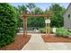 Inviting pool entrance with pergola, lush landscaping, and clear signage for a secure swim at 1630 Marsanne Nw Ter # 27, Kennesaw, GA 30152