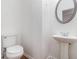 Bathroom features pedestal sink and white toilet, creating a clean and functional space at 4139 Magnolia Glen Walk, Norcross, GA 30093