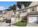Attractive townhome featuring a manicured lawn, attached garage, and traditional architectural details at 4139 Magnolia Glen Walk, Norcross, GA 30093