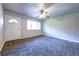 Bright living room with new gray carpet, a ceiling fan, and ample natural light from the large window at 5904 Heatherwood Ln, Riverdale, GA 30296