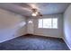 Cozy living room showcasing gray carpeting, a ceiling fan, and a window providing natural light at 5904 Heatherwood Ln, Riverdale, GA 30296