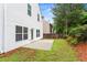 Well-maintained backyard with lawn, flower beds, and a white vinyl siding exterior at 867 Crested Hawk Trl, Sugar Hill, GA 30518