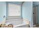 Bright bathroom featuring a soaking tub beneath a window and a glass enclosed shower at 867 Crested Hawk Trl, Sugar Hill, GA 30518