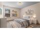 Neutral bedroom features a neatly made bed, decorative shelving, and lots of natural light at 867 Crested Hawk Trl, Sugar Hill, GA 30518