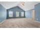 Large bedroom with vaulted ceilings, carpet flooring and plenty of natural light from three windows at 867 Crested Hawk Trl, Sugar Hill, GA 30518