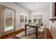 Bright dining room with a modern chandelier, a dining table set for four, and a door leading to the backyard at 867 Crested Hawk Trl, Sugar Hill, GA 30518