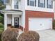 Charming two-story home with a brick and white siding, and a two-car garage at 867 Crested Hawk Trl, Sugar Hill, GA 30518
