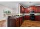 Spacious kitchen with stainless steel appliances, dark wood cabinets, and a view into the adjacent dining area at 867 Crested Hawk Trl, Sugar Hill, GA 30518