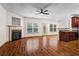 Spacious living room featuring a fireplace, hardwood floors, and a view to the kitchen at 867 Crested Hawk Trl, Sugar Hill, GA 30518