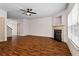 Spacious living room featuring hardwood floors, fireplace and a ceiling fan at 867 Crested Hawk Trl, Sugar Hill, GA 30518