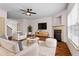 Bright living room with modern ceiling fan, fireplace, and plush white furniture at 867 Crested Hawk Trl, Sugar Hill, GA 30518