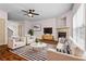 Bright living room features a fireplace, modern furniture, and abundant natural light with windows and door to other rooms at 867 Crested Hawk Trl, Sugar Hill, GA 30518