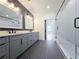 Bathroom featuring a double vanity, shiplap wall, tile floors, and a glass-enclosed shower visible through doorway at 1197 Avondale Se Ave, Atlanta, GA 30312