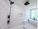 Sleek bathroom featuring a soaking tub, walk-in shower, white marble walls, and mosaic tile flooring at 1197 Avondale Se Ave, Atlanta, GA 30312