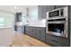 Kitchen featuring stainless steel oven and microwave with gray cabinetry and wood flooring at 1197 Avondale Se Ave, Atlanta, GA 30312