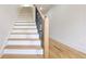 Modern staircase with wood treads, black railing, and white risers at 1197 Avondale Se Ave, Atlanta, GA 30312