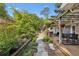 Scenic backyard patio with stone path, pergola, lush garden, mature trees, and dining area at 1280 Sherry Dr, Alpharetta, GA 30009