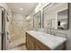 Elegant bathroom with double sinks, marble countertop, and a glass-enclosed shower with bench seating at 1280 Sherry Dr, Alpharetta, GA 30009