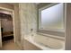 Bathroom featuring a bathtub, tiled wall, and a closet at 1959 Christian Circle, Conyers, GA 30013