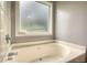 A relaxing bathtub features a large frosted window for natural light and privacy at 1959 Christian Circle, Conyers, GA 30013
