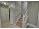 Carpeted staircase with white railing in a neutral-colored entryway with tile floors and nearby laundry room at 1959 Christian Circle, Conyers, GA 30013