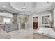 Spacious bathroom with marble tile, soaking tub, glass shower, and chandelier, offering a luxurious spa-like retreat at 212 Fernwood Pl, Woodstock, GA 30188