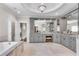 Bathroom featuring vanity with double sinks, marble countertops, cabinetry, and soaking tub, creating a serene and stylish space at 212 Fernwood Pl, Woodstock, GA 30188