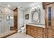 Elegant bathroom featuring a glass shower, wooden cabinets and a stylish oval mirror at 212 Fernwood Pl, Woodstock, GA 30188
