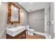 Stylish bathroom features wood-look herringbone floors, a custom wood mirror, and a glass-enclosed shower at 212 Fernwood Pl, Woodstock, GA 30188