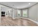 Bright bedroom with light wood floors, white trim, large windows, and an open doorway to other rooms at 212 Fernwood Pl, Woodstock, GA 30188