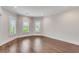 Bedroom featuring three large shuttered windows, hardwood floors, and white walls at 212 Fernwood Pl, Woodstock, GA 30188