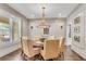 Formal dining room featuring a round table, elegant chandelier, and wainscoting at 212 Fernwood Pl, Woodstock, GA 30188