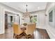 Formal dining room with chandelier and view into kitchen, exposed brick and sliding barn door at 212 Fernwood Pl, Woodstock, GA 30188
