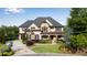 Beautiful two-story home with stone and brick, complemented by lush landscaping and a well-manicured lawn at 212 Fernwood Pl, Woodstock, GA 30188