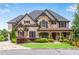 Stunning brick and stone home featuring meticulous landscaping and charming architectural details at 212 Fernwood Pl, Woodstock, GA 30188