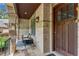Charming front porch with a swing, stone pillars, brick accents, and a cozy seating area at 212 Fernwood Pl, Woodstock, GA 30188