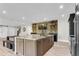 This stunning kitchen boasts a large island, brick accent wall, and custom bar shelves for entertaining at 212 Fernwood Pl, Woodstock, GA 30188