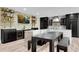 An open kitchen showcases black cabinetry, stone countertops, modern appliances, and a custom bar area at 212 Fernwood Pl, Woodstock, GA 30188
