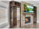 Living room featuring stone fireplace with TV, wooden cabinets and shelving, creating a cozy and stylish gathering space at 212 Fernwood Pl, Woodstock, GA 30188