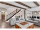 Open-concept living room with exposed wood beams, hardwood floors, and staircase at 212 Fernwood Pl, Woodstock, GA 30188