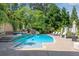Backyard pool with slide, waterfall feature, sun loungers, and beautiful landscaping for luxurious outdoor living at 212 Fernwood Pl, Woodstock, GA 30188