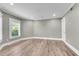 Well-lit room features light wood floors, fresh gray walls, and a window with elegant white shutters at 212 Fernwood Pl, Woodstock, GA 30188