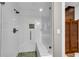 Contemporary white tiled shower with glass door, mosaic accents, built-in bench, and chrome fixtures at 212 Fernwood Pl, Woodstock, GA 30188