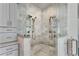 Glass-enclosed walk-in shower with bench, marble tile, and dual shower heads, offering a spa-like experience at 212 Fernwood Pl, Woodstock, GA 30188
