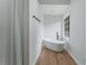 Bright bathroom showcasing a modern soaking tub with black hardware and wood-look flooring at 3285 Country Walk Dr, Powder Springs, GA 30127