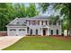 Charming two-story home with a well-manicured lawn, attached two-car garage, and mature trees at 3285 Country Walk Dr, Powder Springs, GA 30127