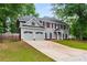 Charming two-story home features a manicured front yard, attached two-car garage, and inviting entryway at 3285 Country Walk Dr, Powder Springs, GA 30127