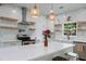 Updated kitchen with a quartz island, a modern range hood, and open shelving at 3285 Country Walk Dr, Powder Springs, GA 30127